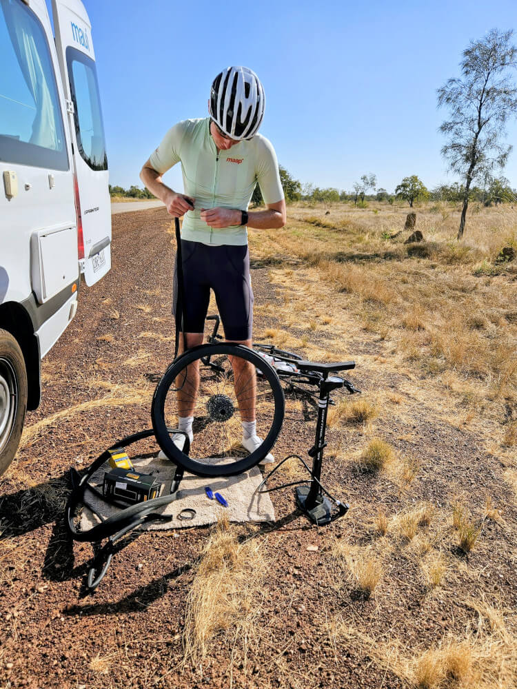 Roadside repairs Tom fixing the puncture beside the support van on our first day out of Broome. Wheel off, tools out and our new life on the road had officially begun. Roadside repairs Tom fixing the puncture beside the support van on our first day out of Broome. Wheel off, tools out and our new life on the road had officially begun.