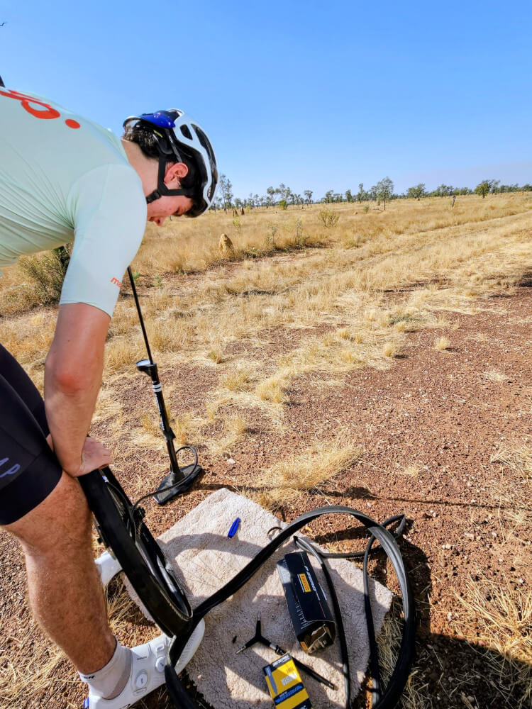 Roadside repairs Tom fixing the puncture beside the support van on our first day out of Broome. Wheel off, tools out and our new life on the road had officially begun. Roadside repairs Tom fixing the puncture beside the support van on our first day out of Broome. Wheel off, tools out and our new life on the road had officially begun.
