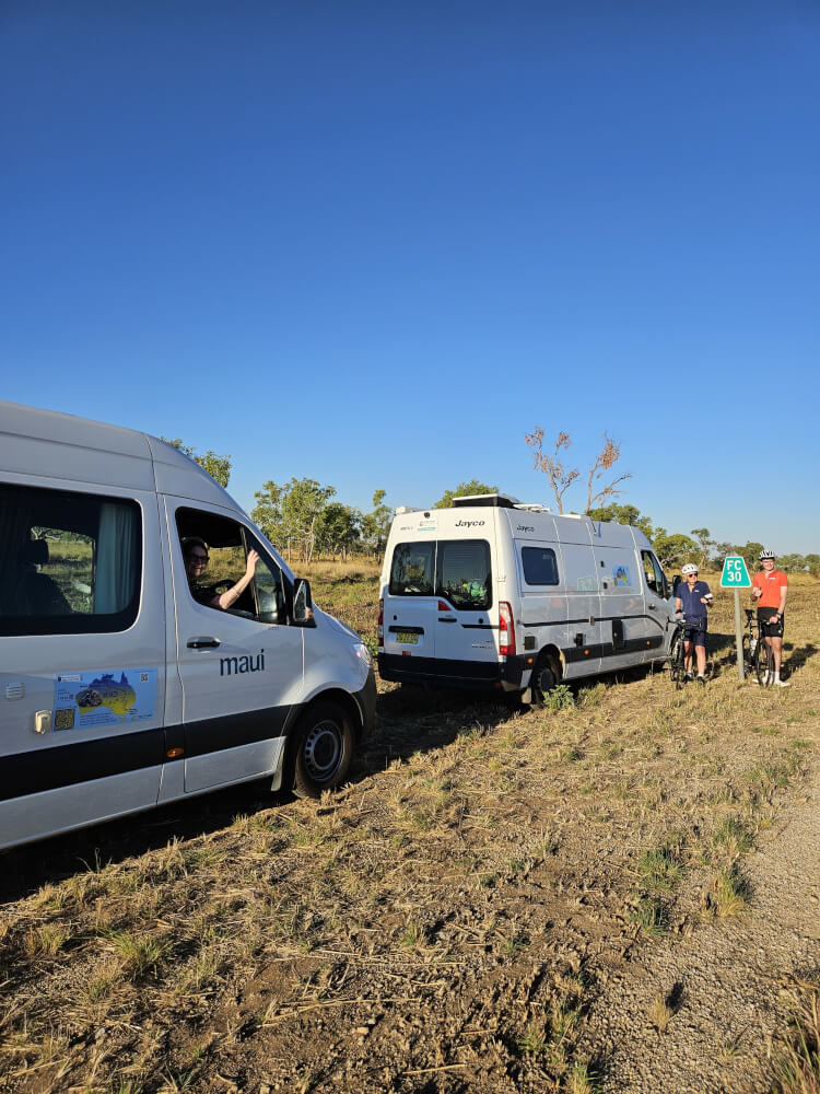 The Broome to Bowral convoy Two support vans and cyclists stopped together beside the Great Northern Highway