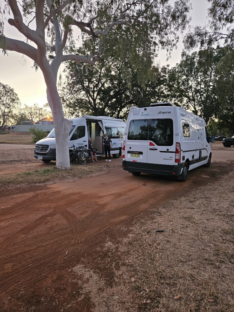 Camp at Fitzroy River Lodge Two support campervans parked beneath trees at Fitzroy River Lodge