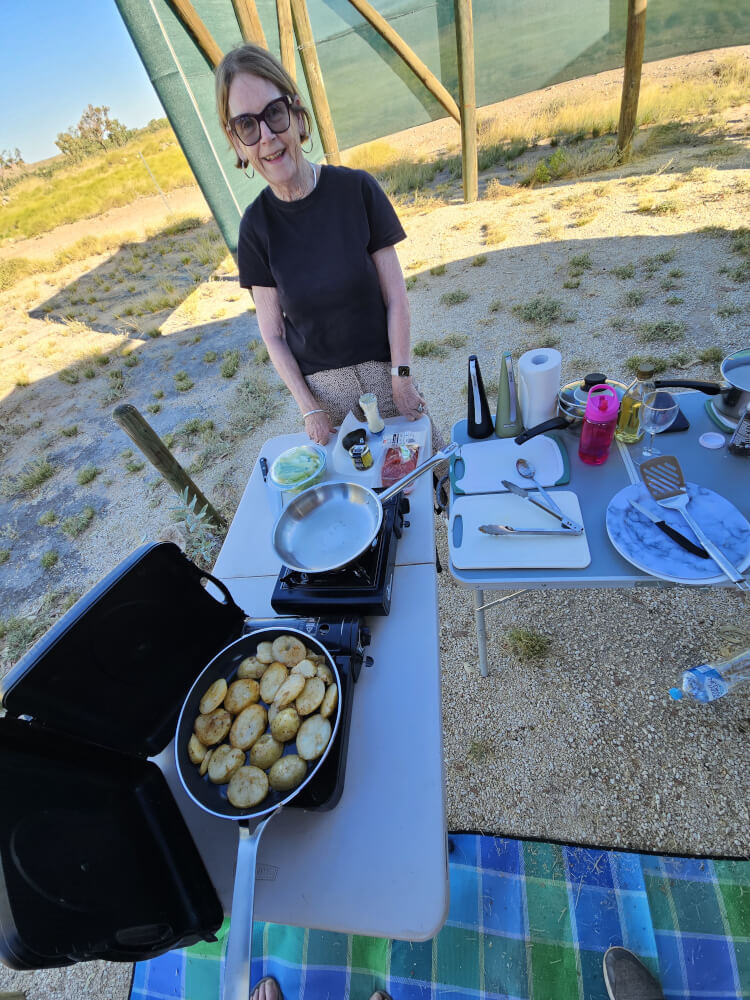 Dinner at Mimbi Jenny cooking potatoes on a portable stove at Mimbi Caves campground