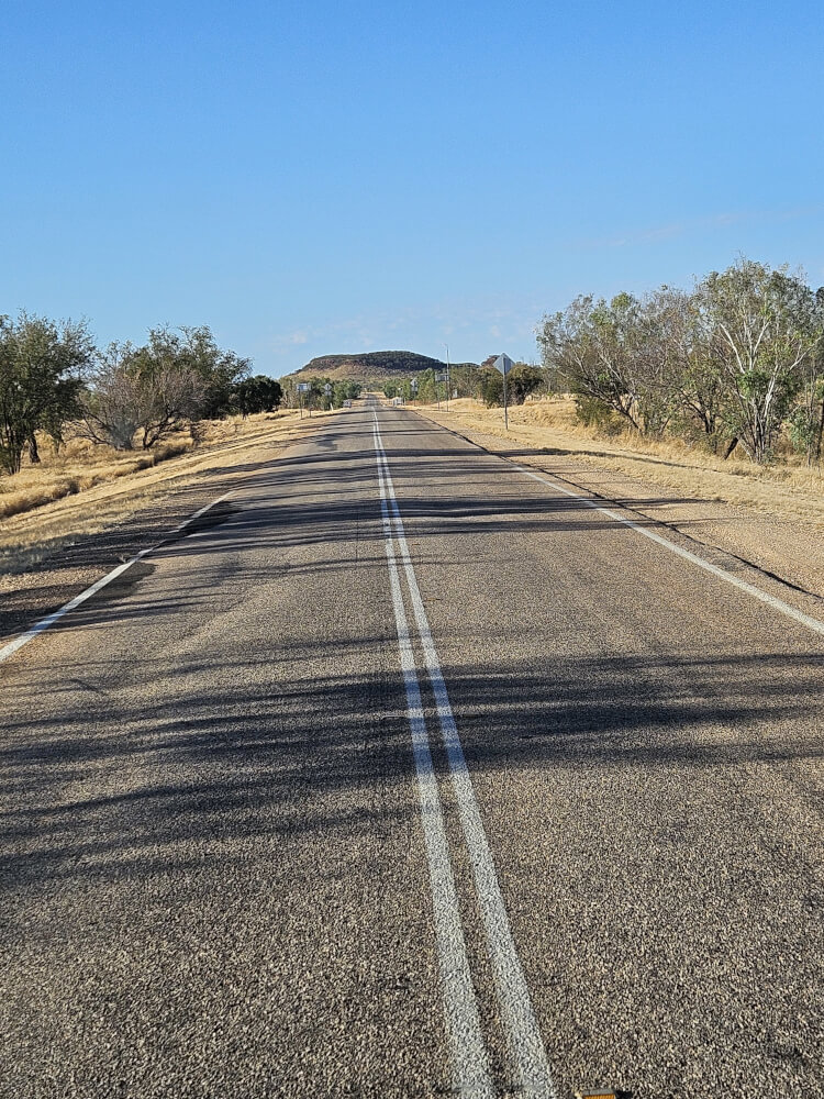The Long Road East Great Northern Highway stretching towards a rocky ridge in the Kimberley
