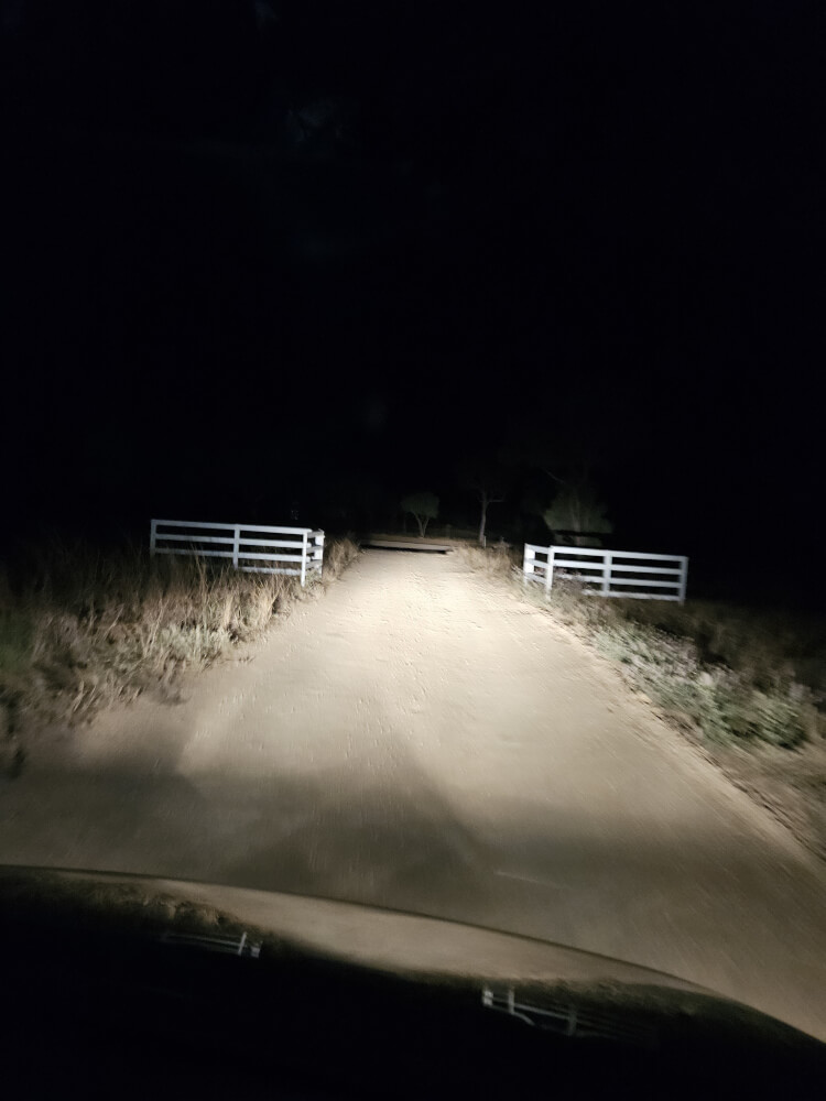 The Road Out of Mimbi Before Dawn Gravel road from Mimbi Caves illuminated by the support van headlights before dawn