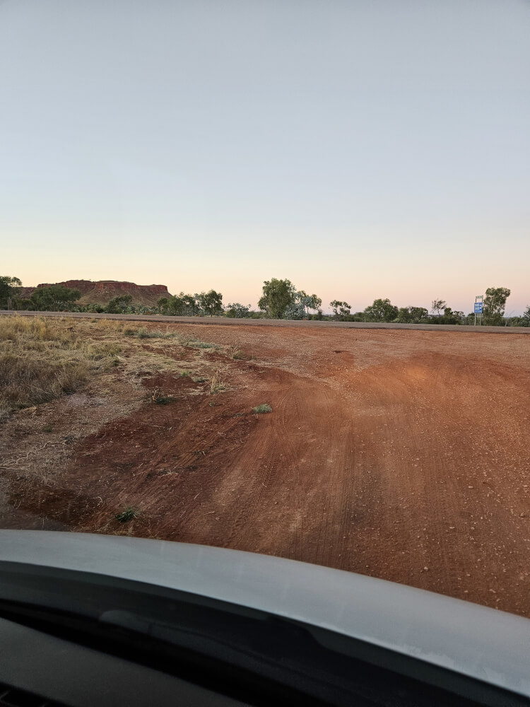 Back to the Great Northern Highway Red gravel road approaching the Great Northern Highway at sunrise