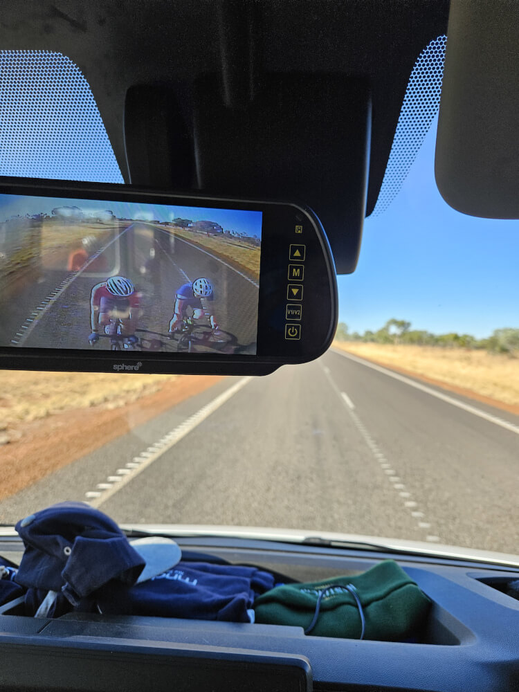 The Relentless Wind Rear-view camera showing Bob and Tom cycling behind the support van