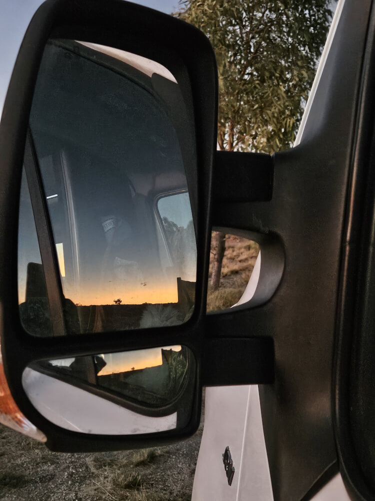 Sunrise in the Van Mirror Pink sunrise reflected in the side mirror of the support van