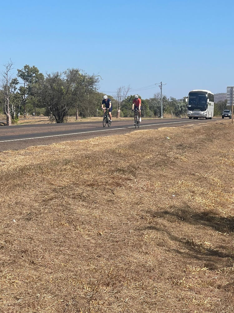 Bob and Tom Arrive in Kununurra Bob and Tom cycling into Kununurra with a coach approaching behind them