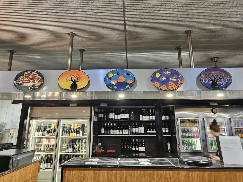 Boab Art at Kelly’s Bar & Grill Colourful circular boab tree artworks displayed above the bar